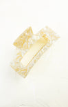 Close-up of a yellow bar of soap with decorative border on a white background