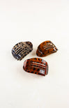 Three tortoiseshell hair clips on a white background