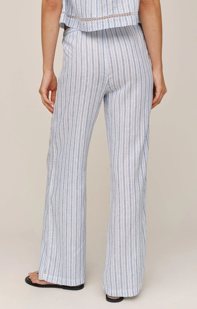 Person wearing light blue and white striped pants on a beige background