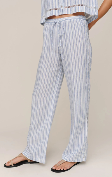 Person wearing blue and white striped pants on a beige background