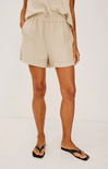 Person wearing beige shorts on a white background