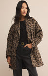 Woman wearing a leopard print coat against a beige background