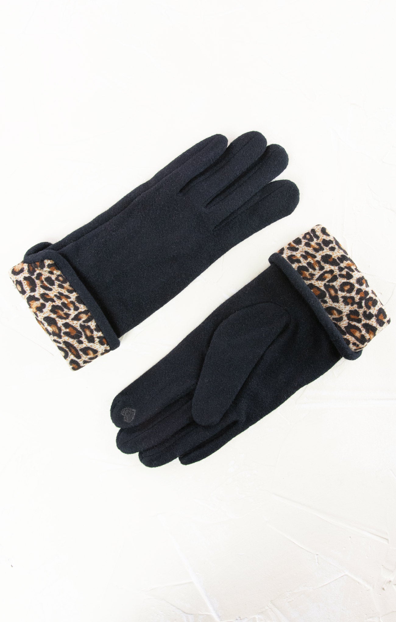 Black gloves with leopard print cuffs on a white background