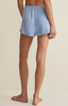 Light blue shorts worn by a person on a beige background