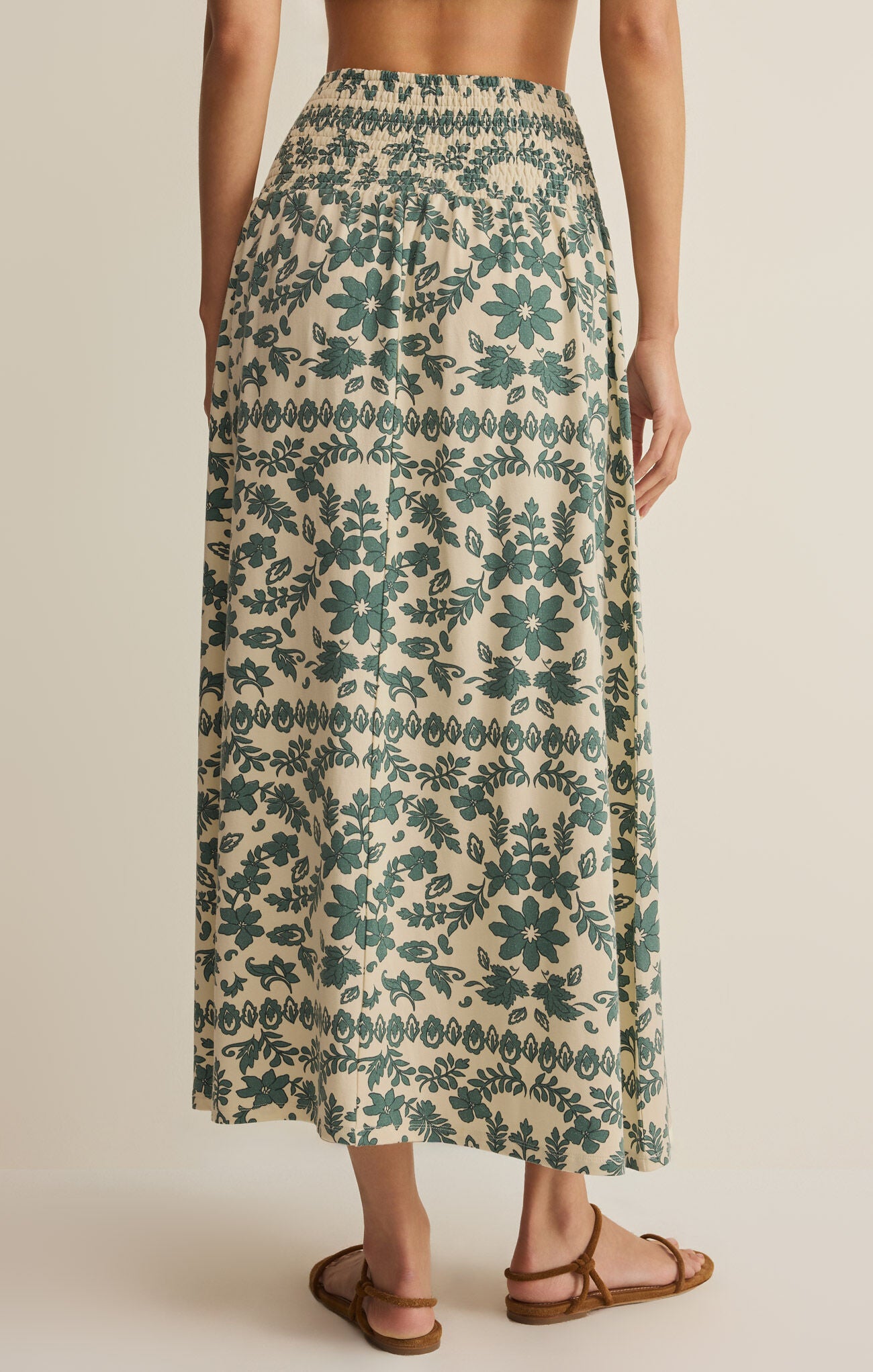 Long floral skirt with green pattern on a neutral background