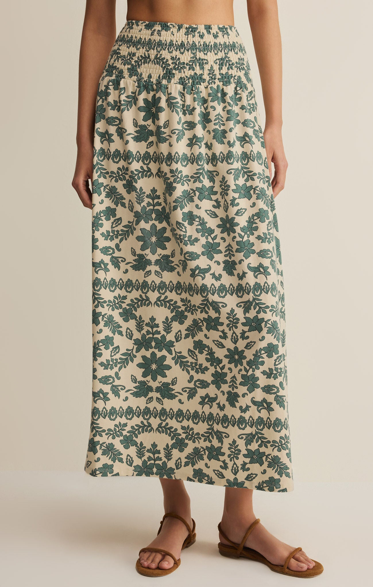 Long floral skirt with green pattern on a neutral background