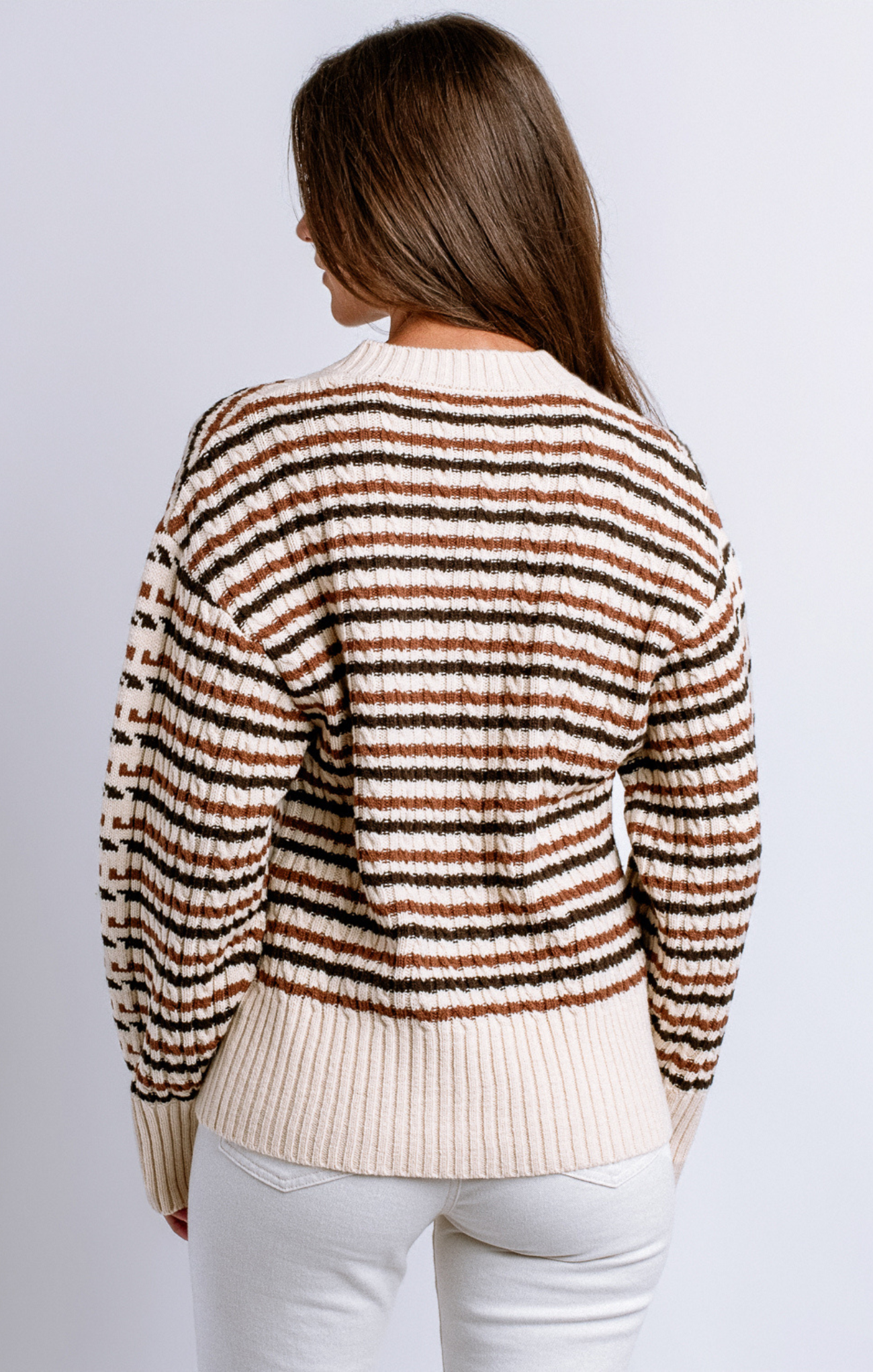 Woman wearing a striped sweater with a plain background
