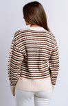 Woman wearing a striped sweater with a plain background