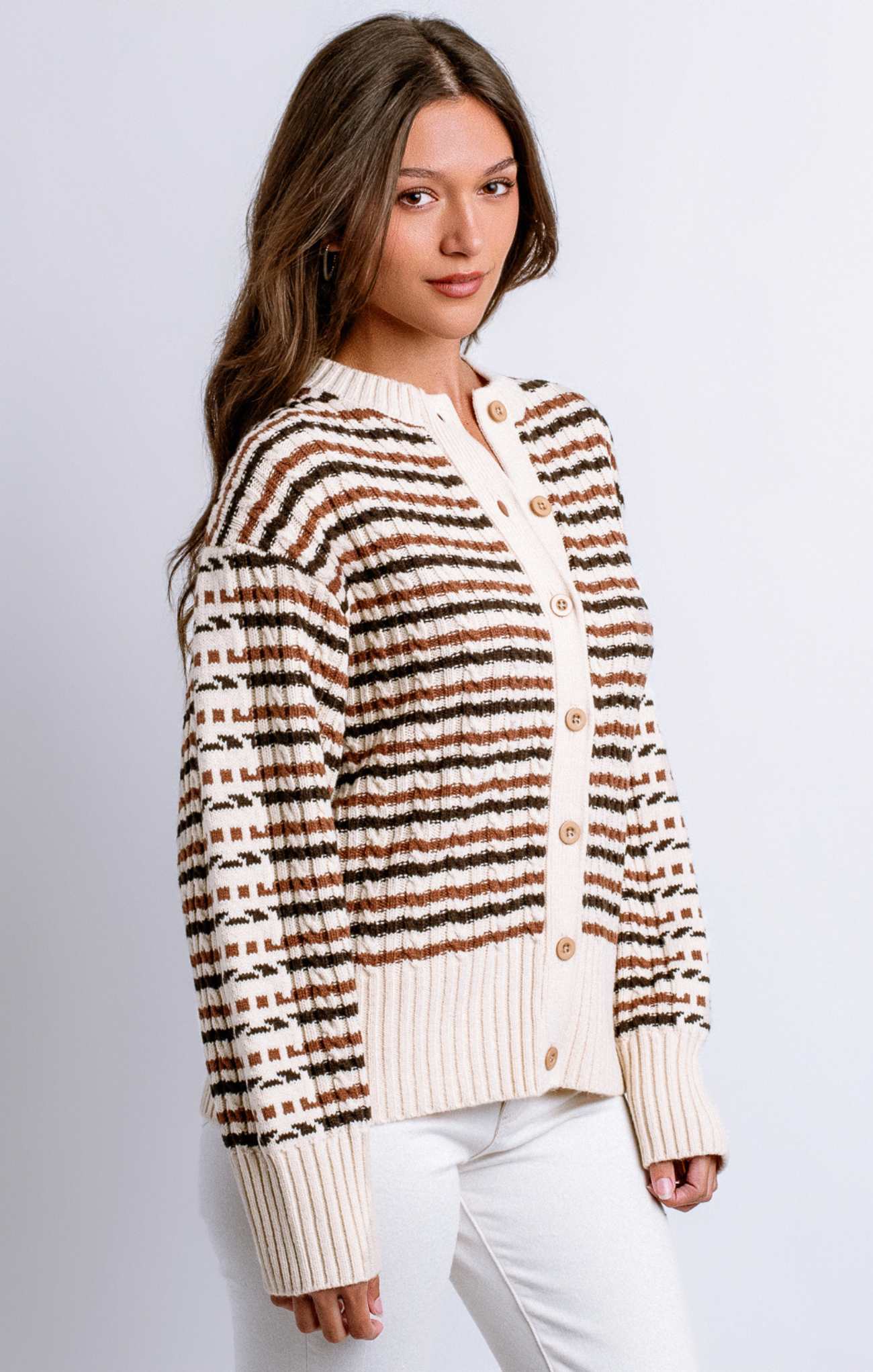 Woman wearing a striped cardigan with a plain background