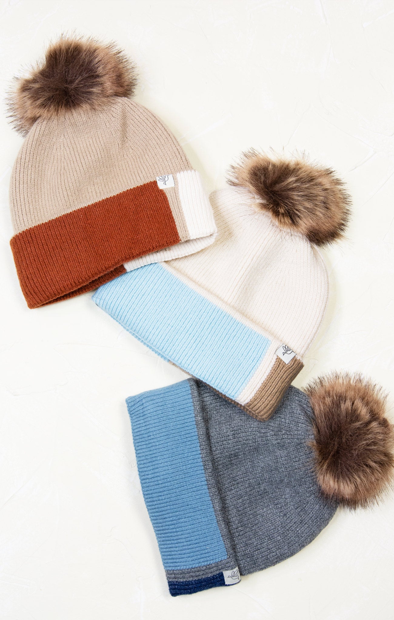 Set of three winter hats with pom-poms on a white background
