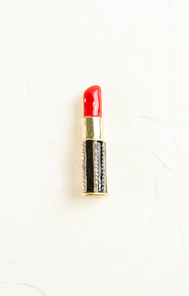 Red lipstick with gold and black casing on a white background
