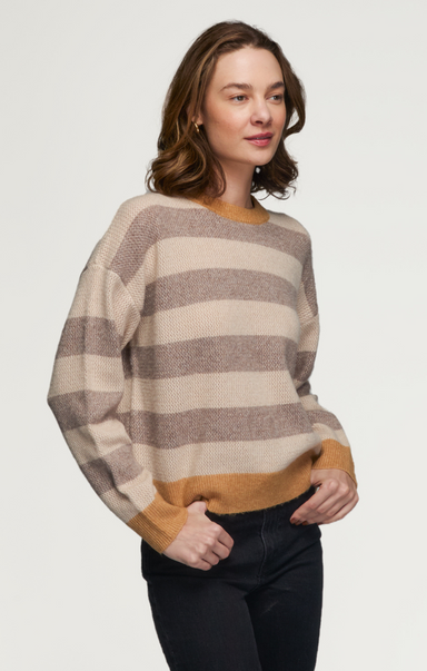 Woman wearing a striped sweater with a neutral background
