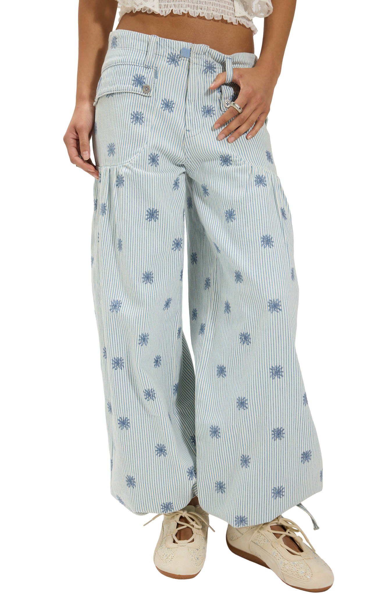 Light blue wide-leg pants with floral patterns worn by a person on a white background