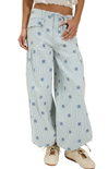 Light blue wide-leg pants with floral patterns worn by a person on a white background
