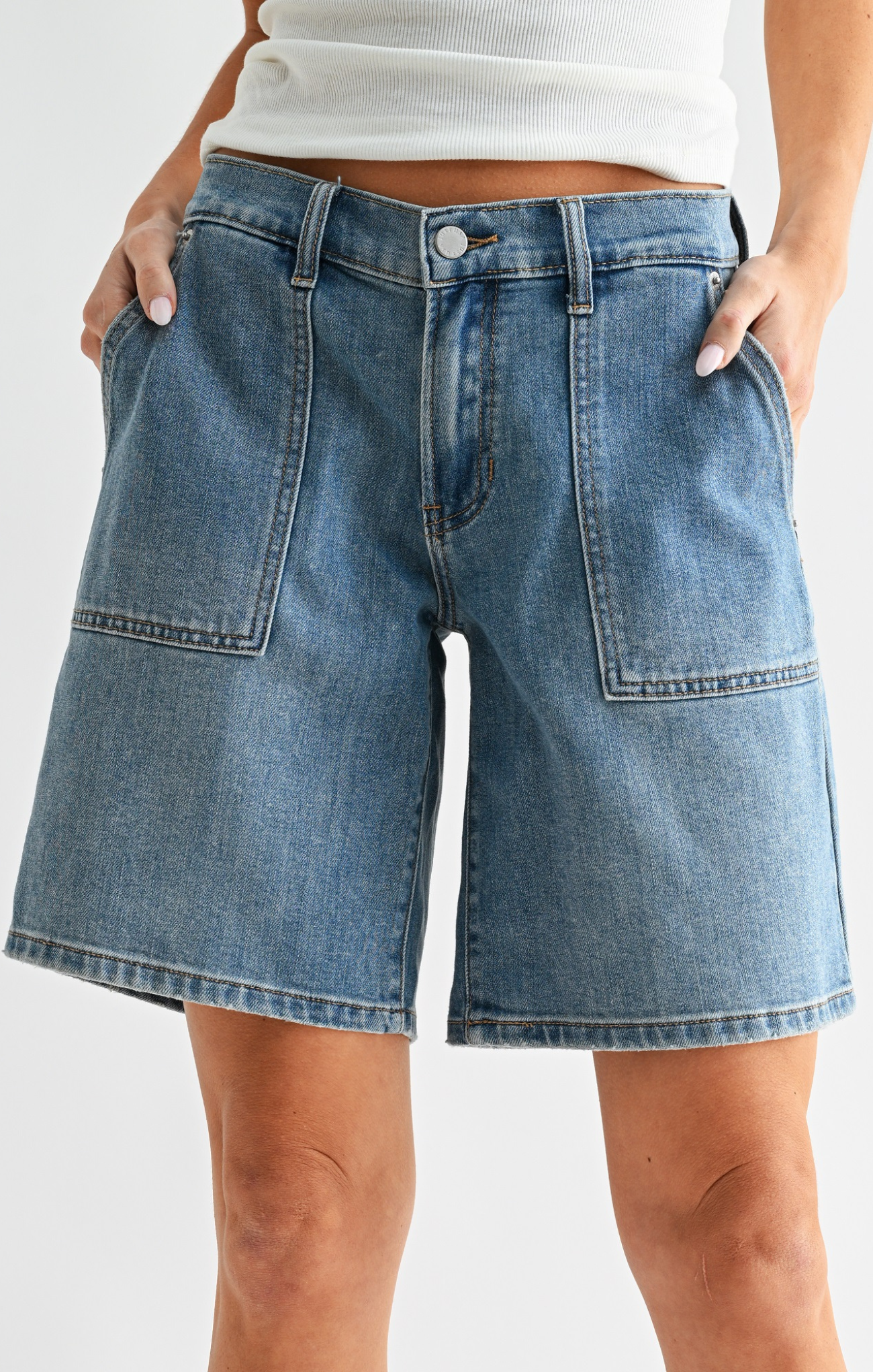 Blue denim shorts worn by a person on a white background