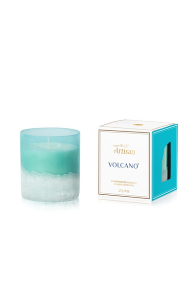 Candle with a blue and white design next to its packaging on a white background