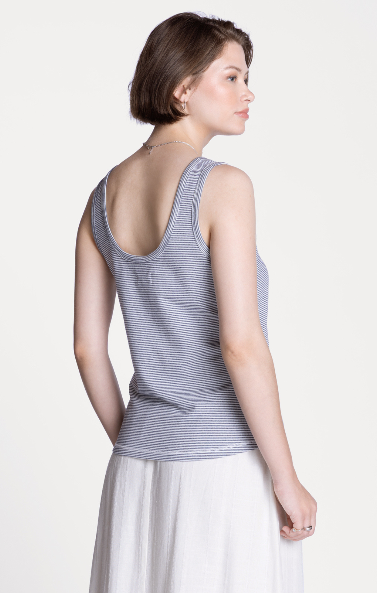 Woman wearing a gray tank top on a white background