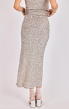 Silver sequin skirt worn by a person on a light gray background