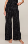 Person wearing black wide-leg pants with white star pattern on a plain background