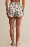 Leopard print shorts worn by a person on a beige background