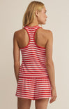 Woman wearing a red and white striped romper against a beige background
