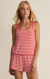 Woman wearing a red and white striped romper against a beige background