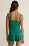 Green romper worn by a person on a beige background