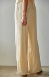 Beige wide-leg pants worn by a person against a plain background