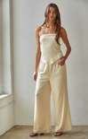 Woman wearing a strapless top and wide-leg pants in a minimalistic setting