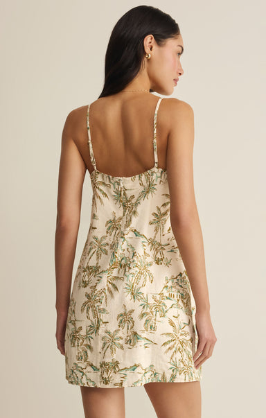 Woman wearing a floral dress with thin straps on a beige background
