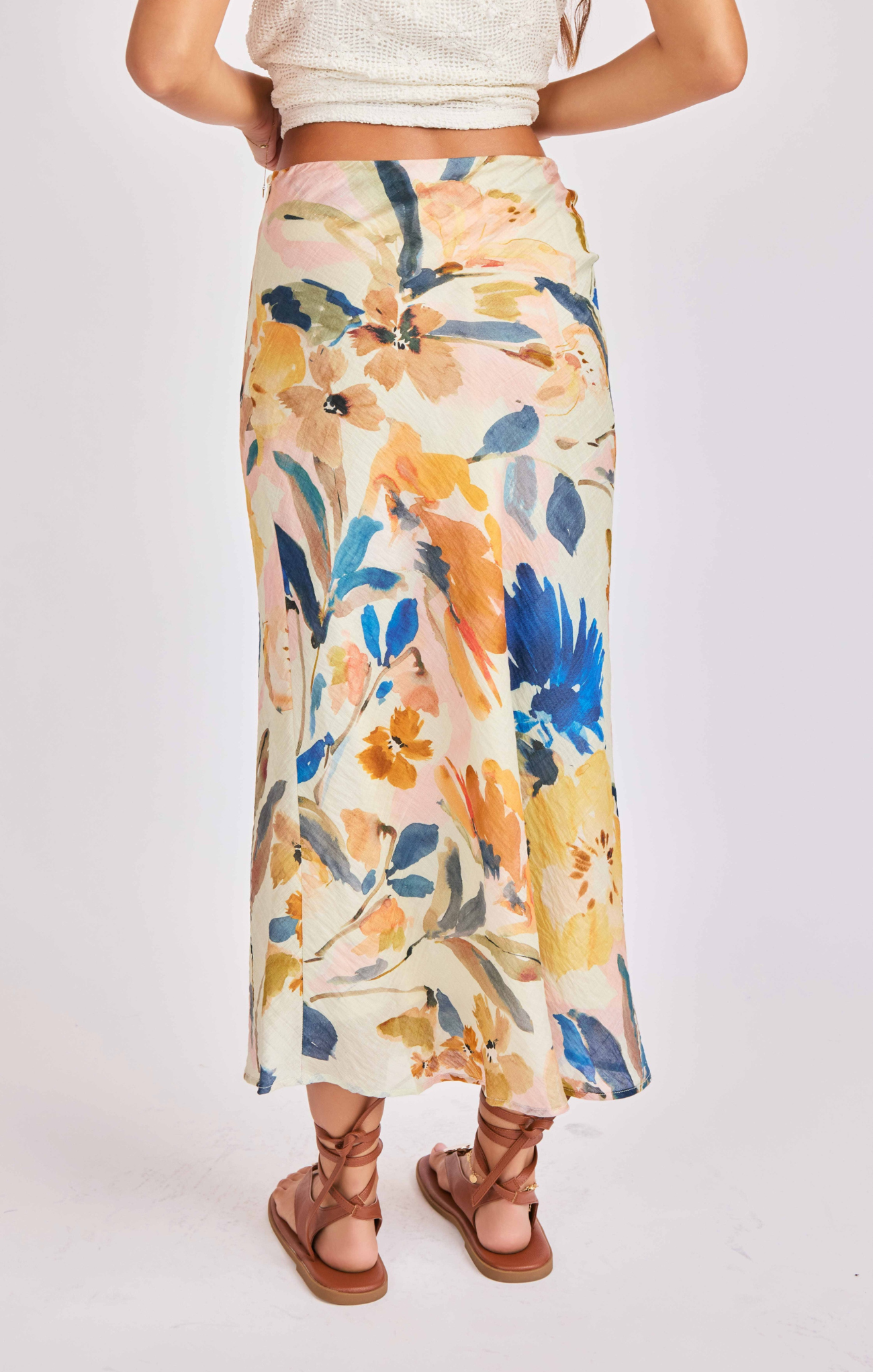 Person wearing a floral skirt with a plain background