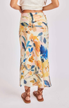 Person wearing a floral skirt with a plain background