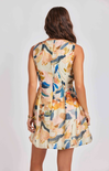 Woman wearing a sleeveless floral dress against a plain background