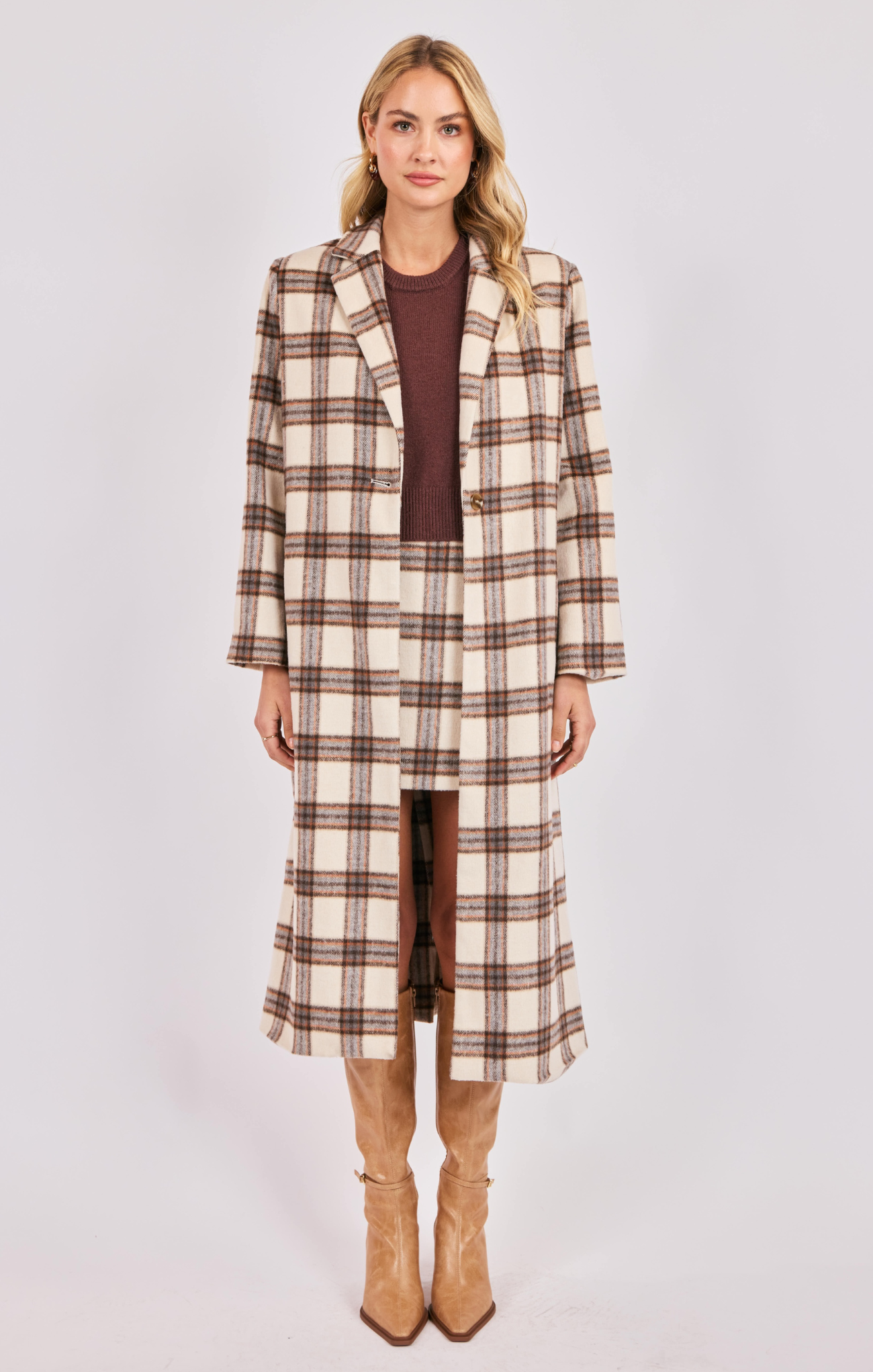 Woman wearing a plaid coat and skirt set on a white background