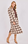 Woman wearing a plaid dress with a white background