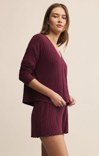 Woman wearing a ribbed knit outfit in a neutral setting