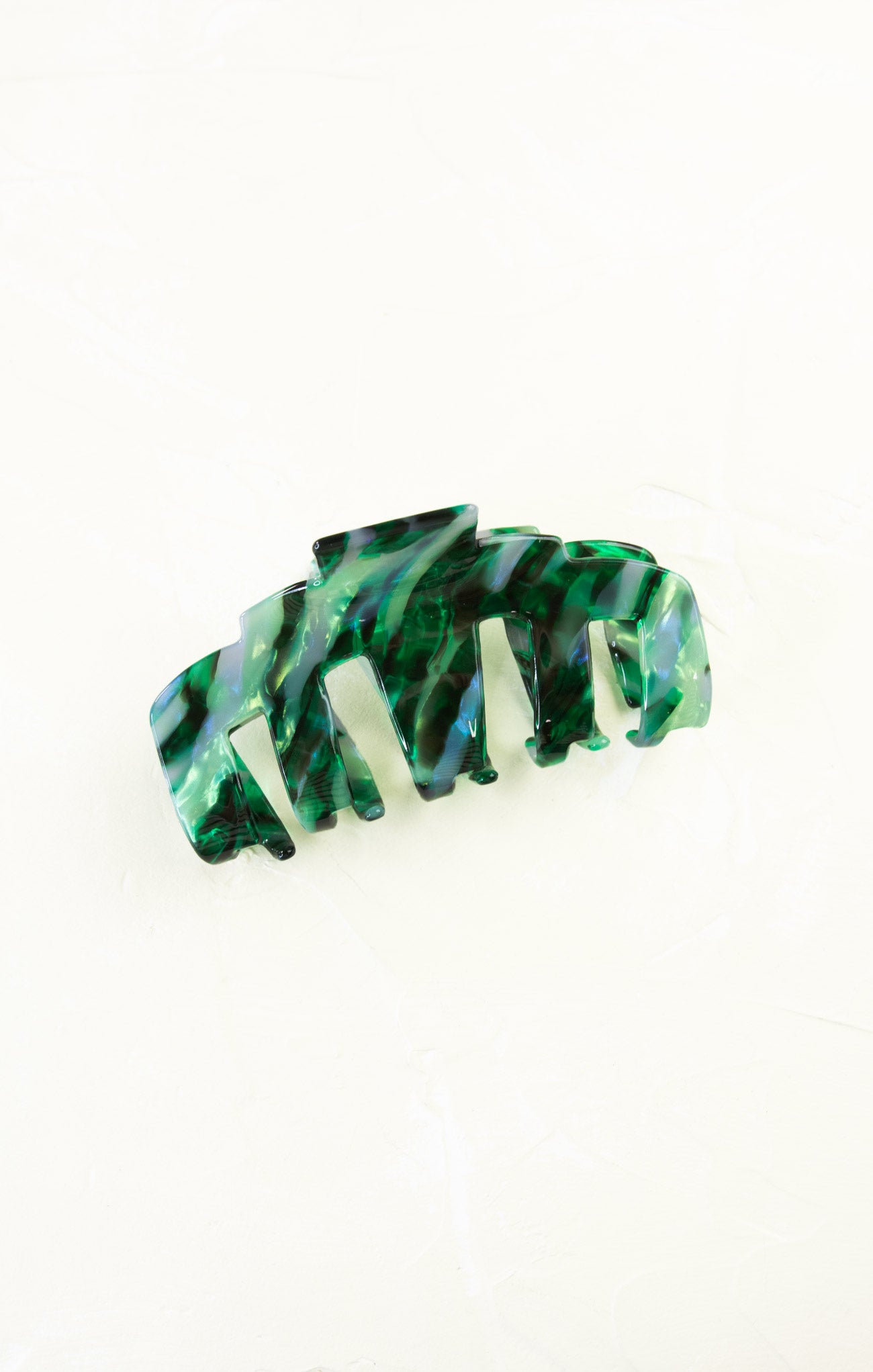 Green and white marbled hair clip on a white background
