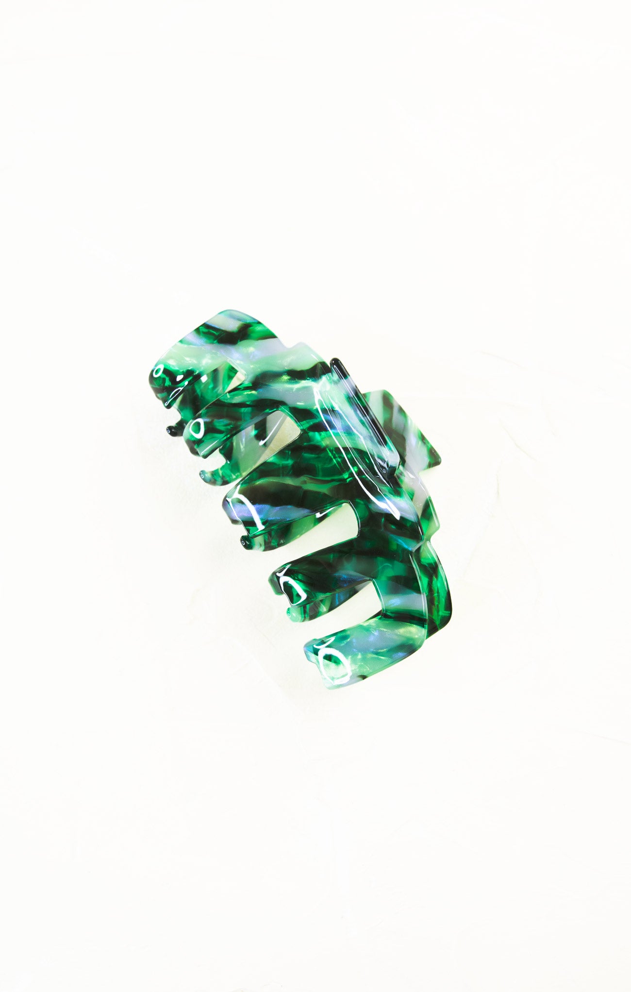 Green and clear hair clip on a white background