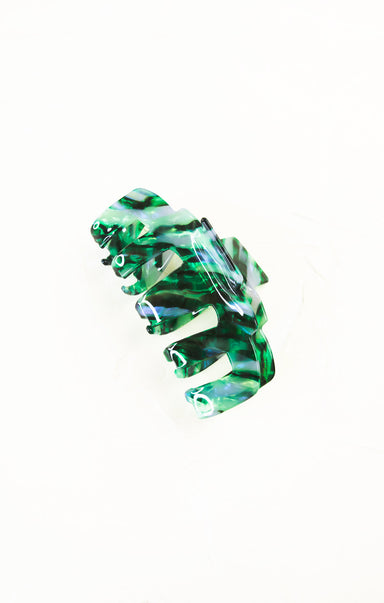 Green and clear hair clip on a white background