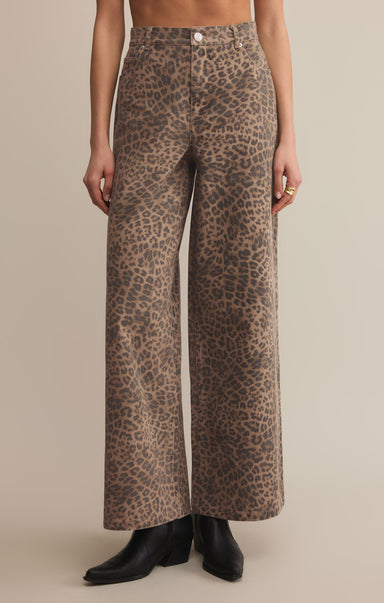 A pair of high-waisted, full-length leopard print denim pants with a zip fly and button closure.