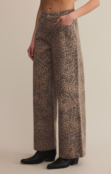 A pair of high-waisted, full-length leopard print denim pants with a zip fly and button closure.