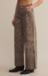 A pair of high-waisted, full-length leopard print denim pants with a zip fly and button closure.
