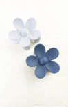 Two flower-shaped objects, one blue and one white, on a white background.