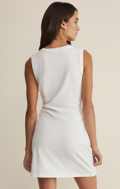 Woman wearing a white sleeveless dress against a beige background