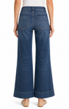 Blue wide-leg jeans worn by a person on a white background