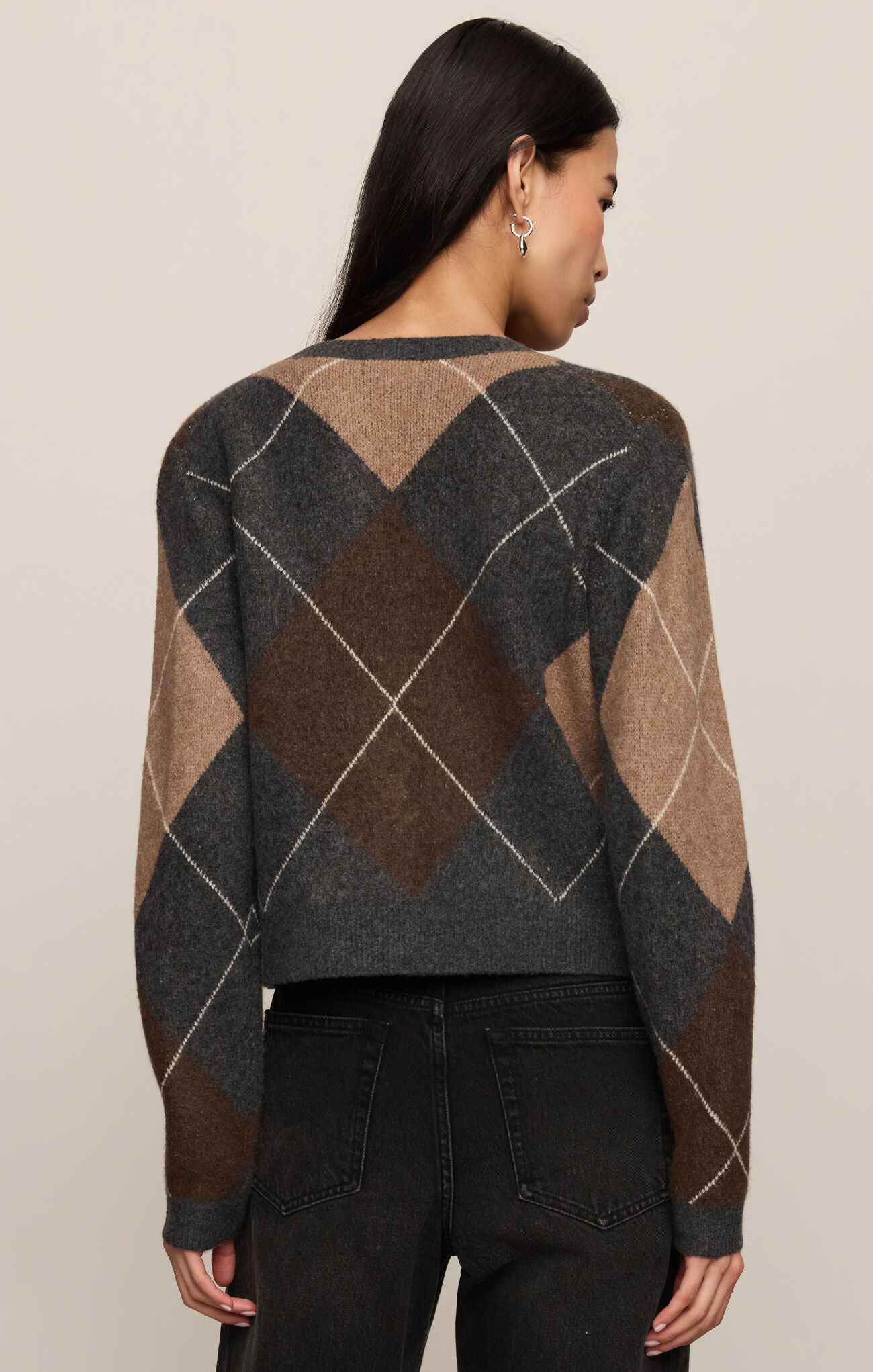 Person wearing a patterned sweater with a neutral background