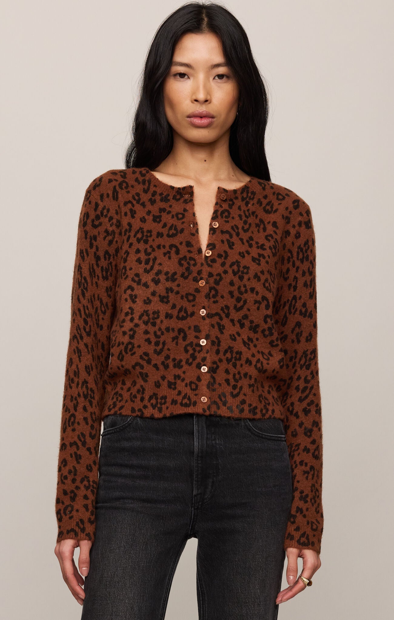 Woman wearing a brown leopard print blouse against a plain background