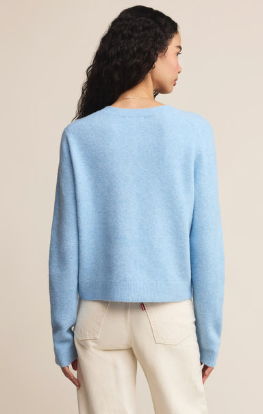 Woman wearing a light blue sweater against a beige background