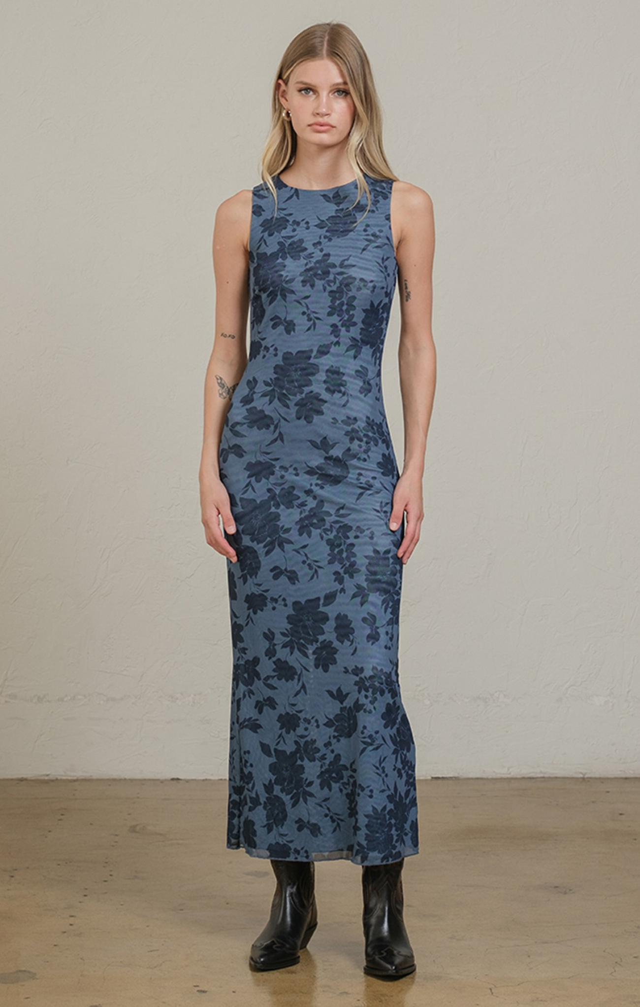 Woman wearing a blue floral dress against a plain background