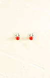 Small red earrings on a beige background